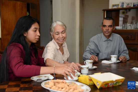 8月12日,在马达加斯加塔那那利佛,彦琳(左一)和奶奶蒙丽嫦(右二)、爸爸弗朗西斯·马尔松(右一)在家中聊天。新华社发(西塔卡·拉乔纳里松摄)
