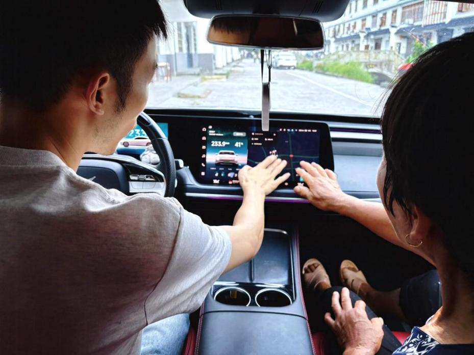 阿豪向村里的老人演示新能源汽车的智能体验。受访者供图